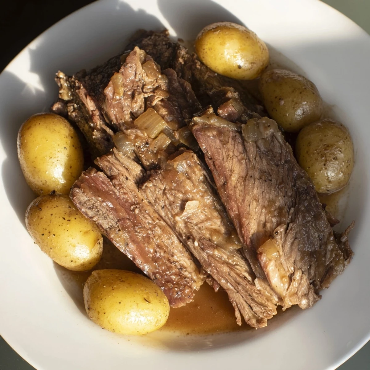 Tender slow cooker pot roast with potatoes, served steaming on a platter.