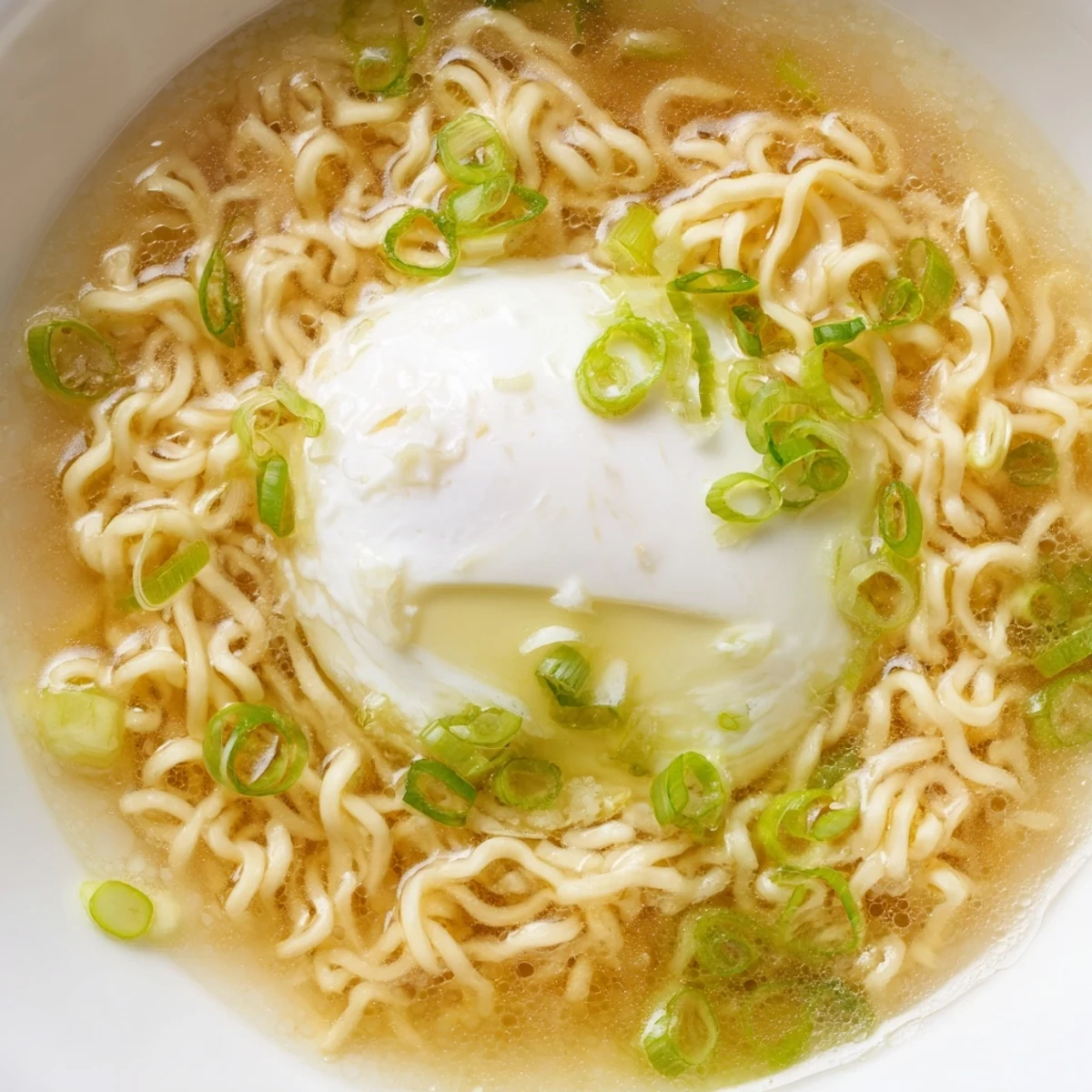 Steaming bowl of upgraded instant ramen with a perfectly cooked soft egg, ready to eat.