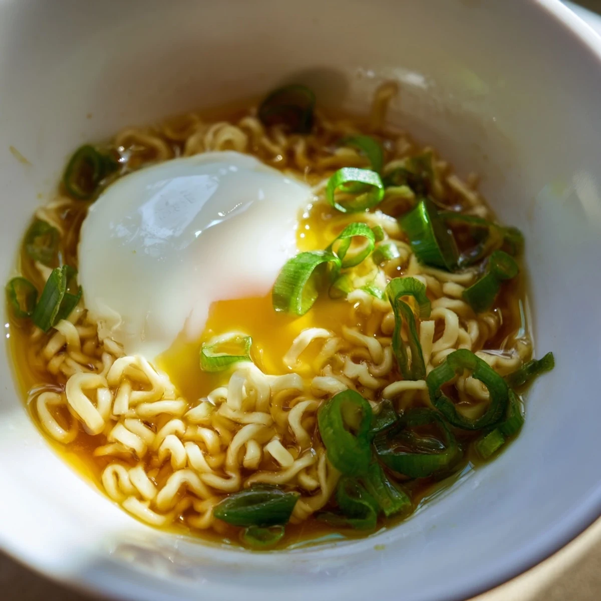 Close-up of savory upgraded instant ramen, garnished with fresh scallions and rich broth.