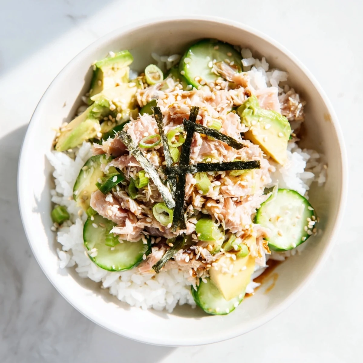 A vibrant Tuna Avocado Rice Bowl with creamy avocado, crisp cucumber, and flaked tuna over fluffy jasmine rice.