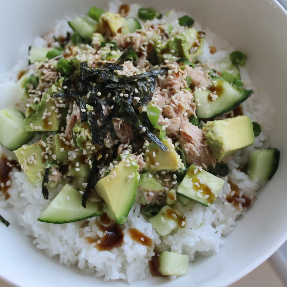 Serve this Tuna Avocado Rice Bowl with drizzled soy-ginger dressing and fresh cilantro for a satisfying dish.