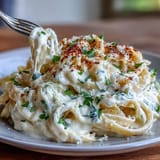 A steaming bowl of Cabbage Alfredo pasta, brightened with fresh parsley garnish.