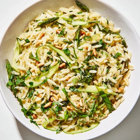 Golden shaved asparagus ribbons mingle with tender orzo pasta in this Asparagus Lemon Orzo Salad, topped with grated Parmesan and toasted pine nuts for a vibrant spring meal.