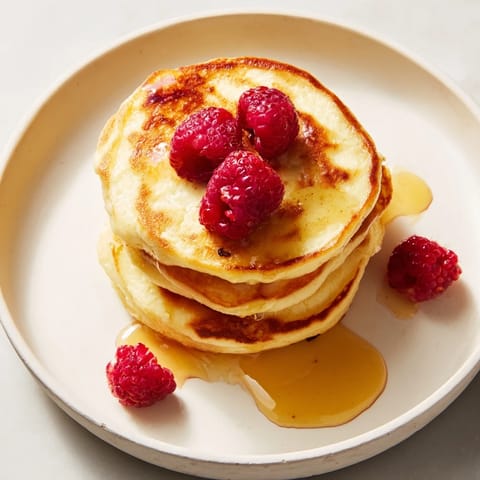 A stack of light and fluffy ricotta pancakes, perfect for dipping in warm maple syrup.