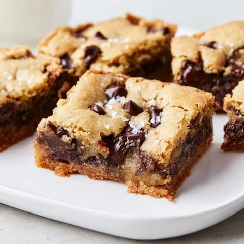 Warm, freshly baked Ultimate Gooey Chocolate Chip Cookie Bars, ready to be sliced and served.
