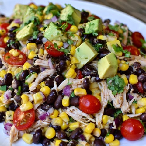 Close-up on a bowl of flavorful Dense Southwestern Bean Salad, perfect for a summer gathering.