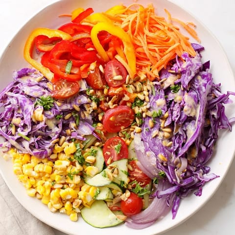 Freshly tossed Rainbow Salad, presenting crisp carrots, peppers, and tomatoes ready to eat.