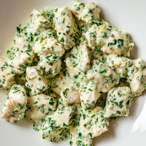 Freshly blended Green Goddess Chicken Salad with herb dressing, served on a platter with cucumber slices and toasted nuts nearby.