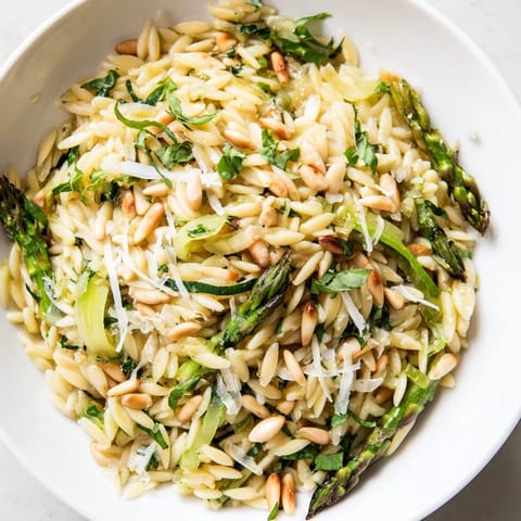 Zesty lemon dressing glistens on every spoonful of this Asparagus Lemon Orzo Salad, featuring bright greens, al dente pasta, and optional baby arugula for a fresh Mediterranean side.