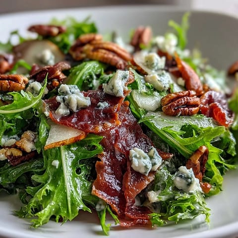 Gourmet Frisée, Pear, Blue Cheese, and Crispy Prosciutto Salad, drizzled in tangy vinaigrette.