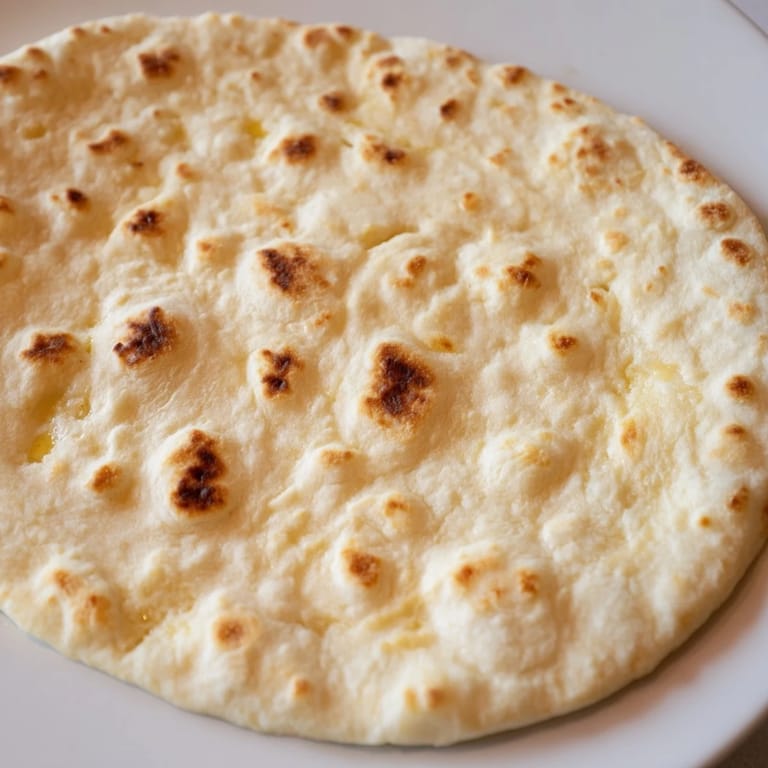 Freshly cooked Three-Ingredient Easy Flatbreads, each showing lightly puffed and charred spots from the skillet.