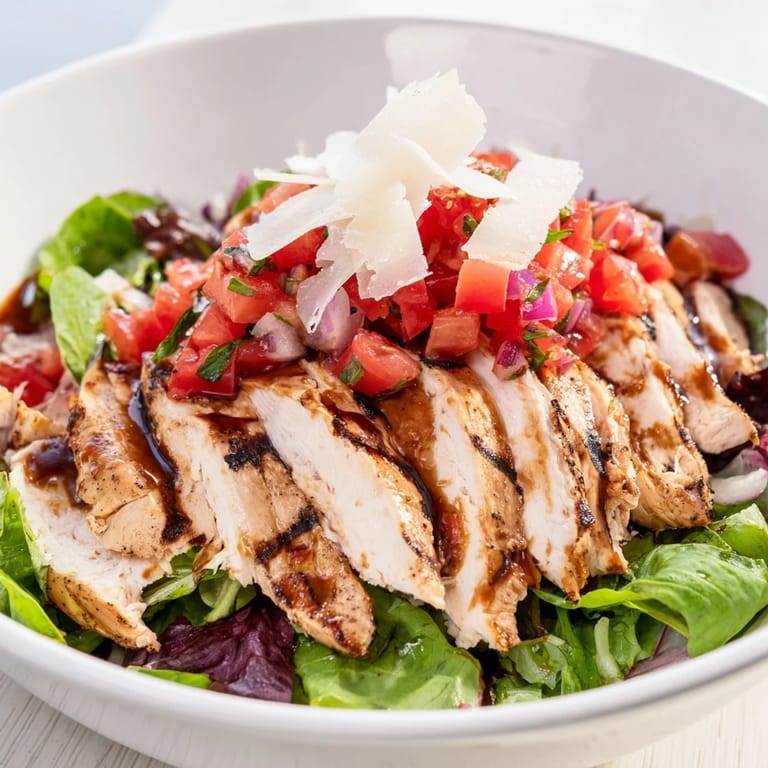 Juicy grilled chicken breast is served over crisp salad greens, finished with a colorful bruschetta topping of tomatoes and fresh basil in this Bruschetta Chicken Salad.  