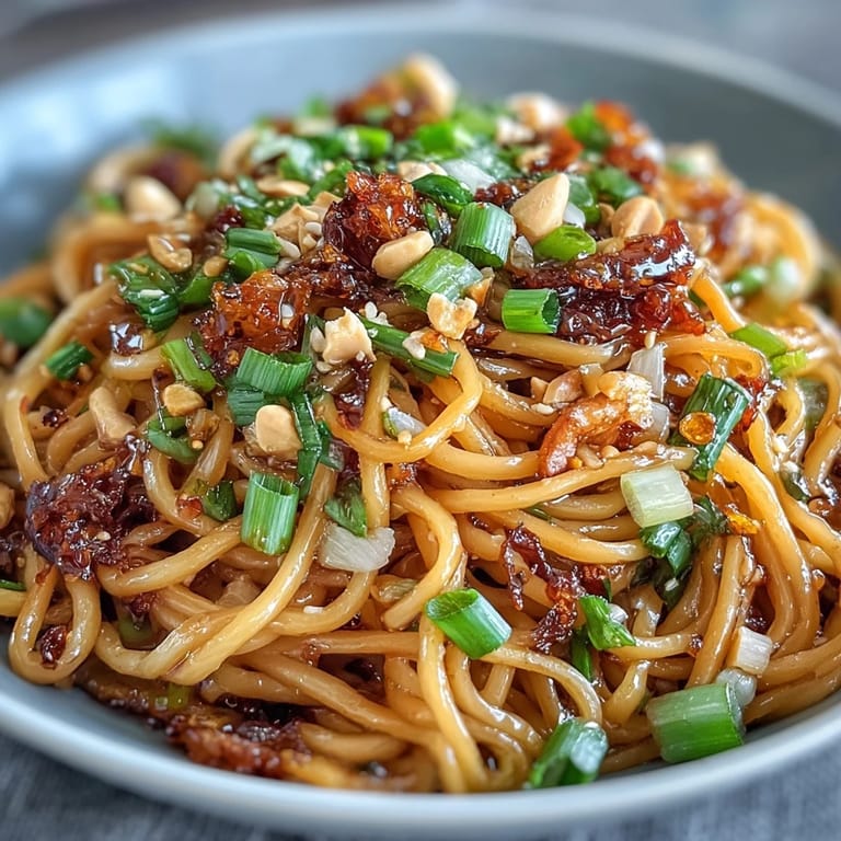 Delicious Chili Crisp Noodles, topped with crunchy peanuts and vibrant green onions.
