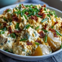 Creamy deviled egg potato salad with tender Yukon Gold potatoes and tangy mustard dressing, perfect for summer picnics and BBQs.