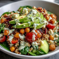 Vibrantly colorful Ancient Grains Bowl with creamy tahini dressing atop tender farro and quinoa.